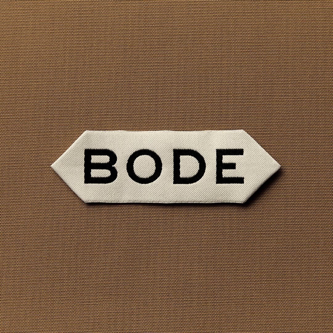 1604-bode-black-wordmark-white-label-brown-fabric-brown-grey-square-reference-only.jpg